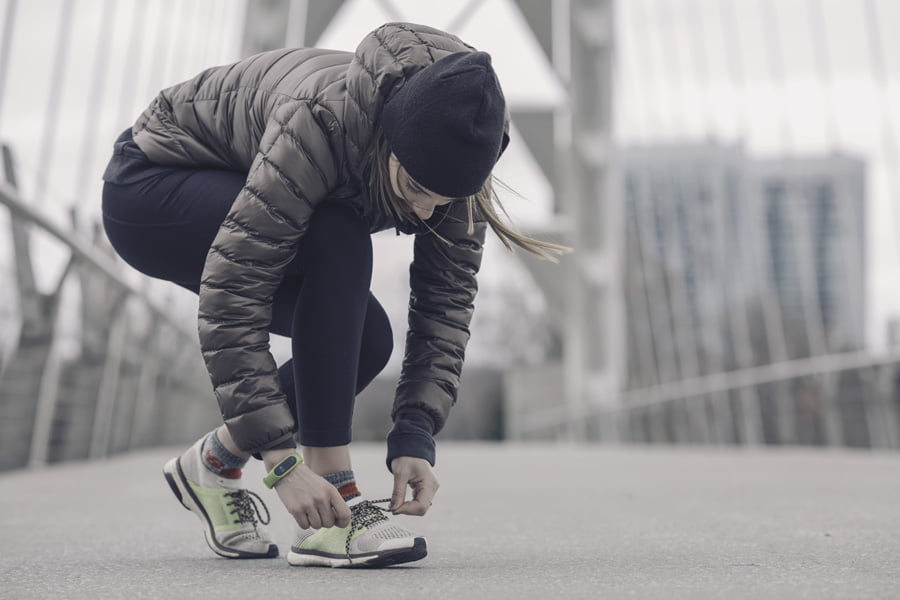Woman tying her running shoes - Link to Highland Health Store online shop - products category Sport and Nutrition - see vegan, vitamins and supplements products